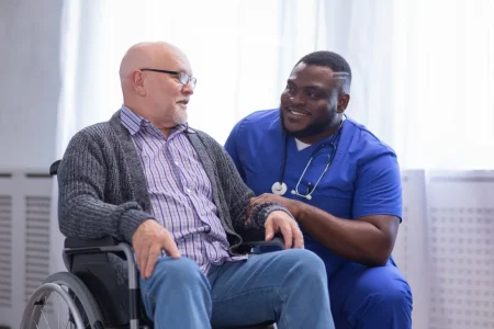 Disabled man in wheelchair talking with male nurse